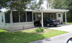 This 28' x 36' home has a double carport, a 12' x 12' front, raised, screened and vinyl windowed Florida room, carpeted and furnished and a split bedroom plan. An interior washer & dryer laundry room with W/D, side by side refrigerator, skylights, smoke