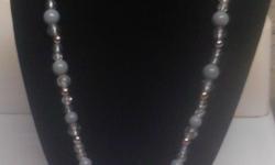 I have crafted a beautiful handmade glass bead necklace. Its medium sized so its right there in the center of your chest. The sparkling cracked glass beads give it the sparkle of shine that a diamond would also, assorted silver and grey are also found in