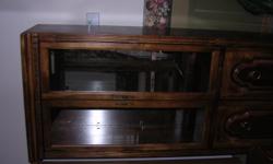 Attractive curio cabinet that measures 76"H x 32"W x 19"D. I believe it is maple and has nice dental molding detail on top. Display part of cabinet has two glass doors, a light to illuminate space, full-mirrored back, and two adjustable glass shelves.
