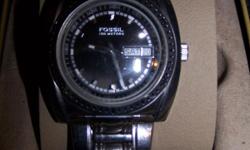 Stainless Steel cover and band with a black round face. A real man's watch. It is heavy duty.