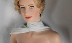 &nbsp; This pretty 18" Portrait Doll recreates Princess Diana in one of her most famous gowns. She is made of bisque porcelain with hand painted features. Her blue chiffon gown has a matching scarf that crosses in front and down in back to the floor. It