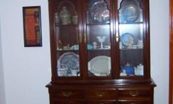 ETHAN ALLEN DINING SET WITH HUTCH $1500.00 it extends to 104" and has the hot pad to cover the solid cherry wood table. The China hutch is matching and sold cherry as well. It has small glass panes in the wood shelves, three drawers, three lower doors
