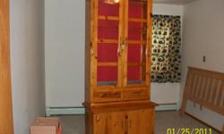 Pine gun cabinet with glass doors and storage which all locks. Also has a back light inside. Excellent condition and is in two pieces. Holds 10 long guns.