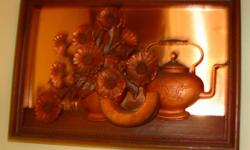 Vintage tooled metal art picture of teapot. Copper colored metal in the background.